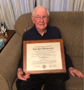 Alfred Abraham poses with his diploma from New York University